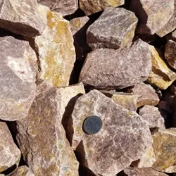 Blush 2 - 4 inch gravel, showcasing a captivating blend of stones in soft blush tones, ranging in size from 2 to 4 inches, with a quarter for size reference. Discover the elegance of this gravel available at Albuquerque Landscape Supply, ideal for creating stunning garden accents, walkways, or decorative features that evoke a sense of tranquility and beauty.