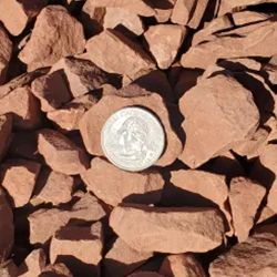 A vibrant mix of multi-colored gravel stones, featuring shades of red, orange, and beige, offering an eye-catching option to add warmth and visual interest to any Albuquerque landscape designs, pathways, and decorative elements.
