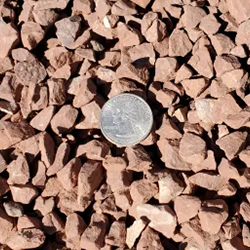 A close-up view of mostly red light-colored gravel stones in varying sizes, ranging from fine to medium. These smooth gravel stones, available at Albuquerque Landscape Supply, are perfect for creating a serene garden pathway or adding elegance and texture to your outdoor space. Enhance your landscape design with this high-quality decorative gravel, ideal for low-maintenance and visually appealing yards near you.
